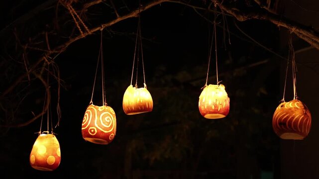 Hanging lanterns with candles and handmade carvings, fall background