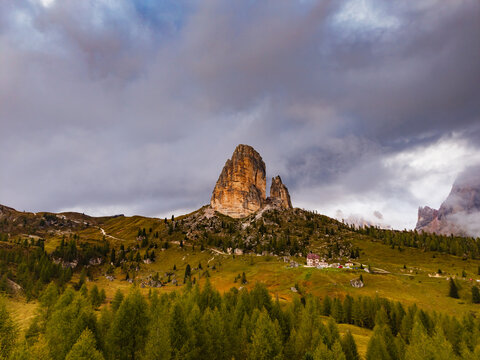 Aerial view of the majestic Cinque Torri peaks rise dramatically against a backdrop of moody skies and autumnal hues, Cortina d'Ampezzo, Veneto, Italy.