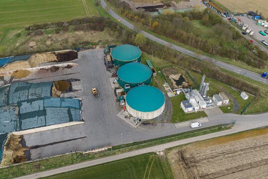 Aerial view of a biogas plant with its circular green roofs contrasting against the raw materials and surrounding fields, Gross-Umstadt, Hessen, Germany.