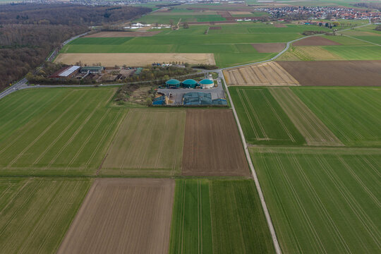 Aerial view of a biogas plant nestled amidst patchwork fields of green and brown, a testament to sustainable energy amidst the rural landscape, Gross-Umstadt, Hessen, Germany.