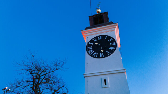 Aerial view of the iconic clock tower standing tall against the crisp blue sky, a timeless landmark in Petrovaradin, Vojvodina, Serbia.