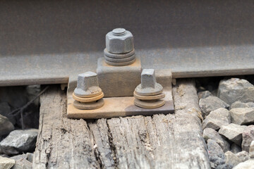 Śruba i mocowanie szyny kolejowej do podkładu, zbliżenie elementów torowiska, infrastruktura kolejowa i utrzymanie torów. © Henryk Guziak