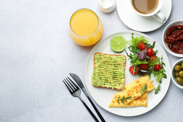 Fototapeta premium Healthy breakfast with delicious avocado toast served on light table, flat lay. Space for text