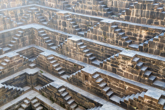 View of the ancient Chand Baori stepwell's intricate geometric patterns carved into the stone, creating a mesmerizing descent, Bandikui, Rajasthan, India.