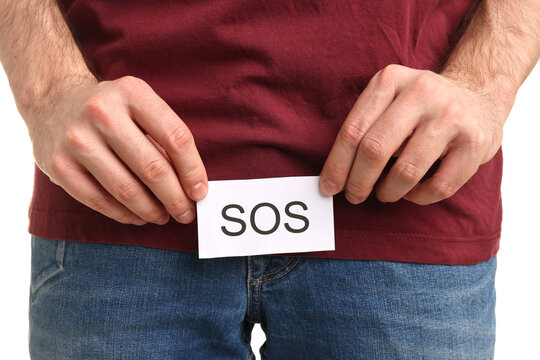 Urology. Man holding note with word SOS on white background, closeup