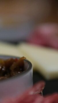 Taking meat with a fork from Charcuterie board with various cured meats and sausages close up. High quality 4k footage