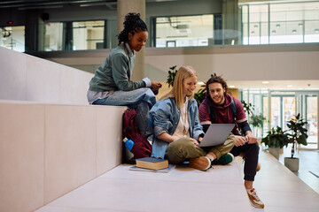 Obraz premium Multiracial group of happy students using laptop at university.