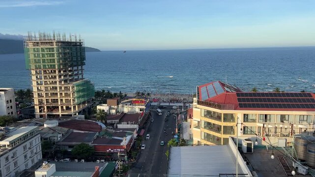 Danang from hotel showing street, ongoing construction, new buildings, and distant ocean. Urban cityscape with modern development and coastal scenery.