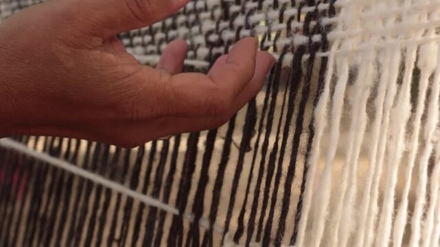 Mujer ind&iacute;gena argentina teje un poncho en telar con lana hecha a mano