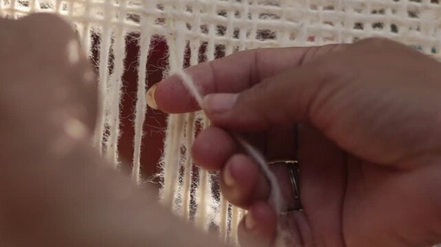 Mujer ind&iacute;gena argentina teje un poncho en telar con lana hecha a mano