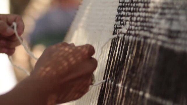 Mujer ind&iacute;gena argentina teje un poncho en telar con lana hecha a mano