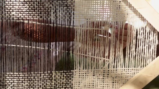 Mujer ind&iacute;gena argentina teje un poncho en telar con lana hecha a mano