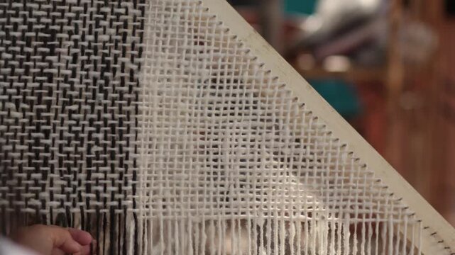 Mujer ind&iacute;gena argentina teje un poncho en telar con lana hecha a mano