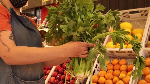 Apio en manos en una verduleria