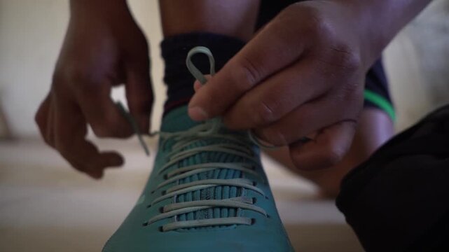 ni&ntilde;o se ata los cordones de sus botines