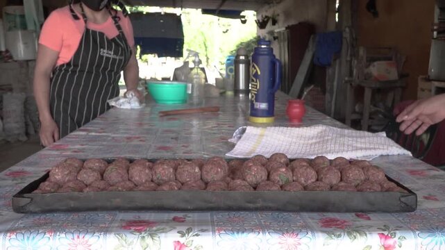 Mujeres cocinan albondigas de carne