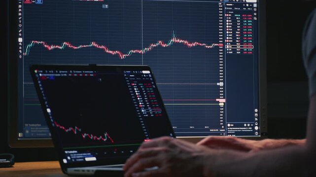 Close up: businessman hands working on laptop or computer keyboard for trading or stock market investing. Male investor sells and buys Bitcoin and crypto coins. Trader chart on terminal monitor.
