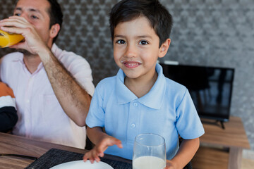 latin little boy child having breakfast at home in Mexico Latin America, hispanic family eating together at morning © Marcos