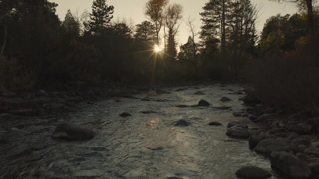 An aerial flyover the Cache La Poudre river with the setting sun near Rustic, CO