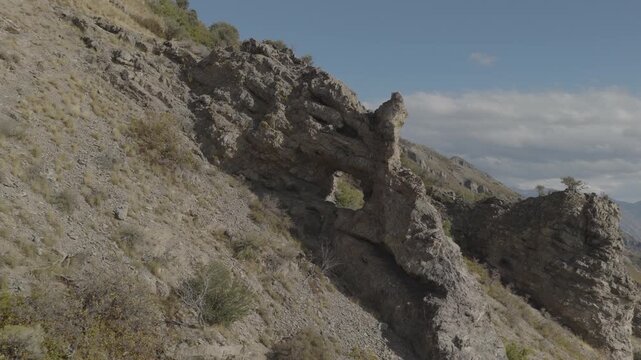 An aerial shot of a strange rock formation and arch above Utah Valley, Uinta National Forest, UT