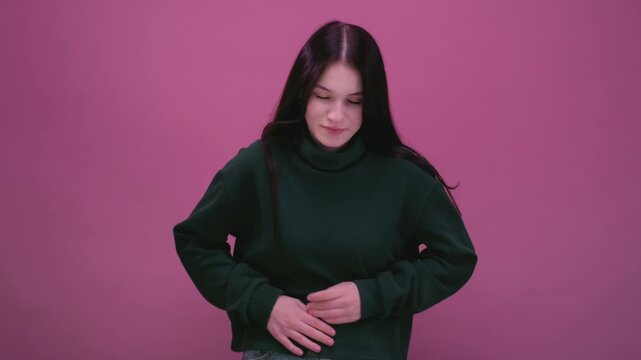 Teenage girl feels abdominal pain. White woman with black hair squeezing belly with hands. Suffering stomach. The young female starts menstruating. Teenager complains of terrible stomach pains.