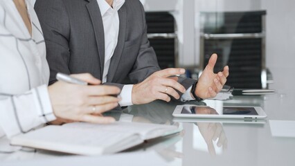 Fototapeta premium Business people hands discussing data on digital tablet during an office meeting, planning strategy and analyzing results