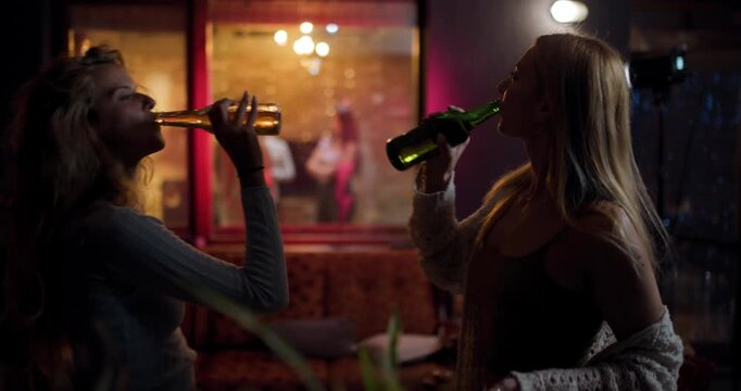 Friends enjoy drinks and laughter in a cozy bar setting during a night out with warm lighting and upbeat atmosphere in the background
