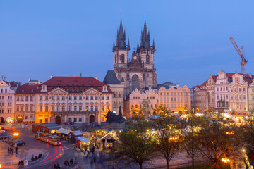 Obraz premium Old Town Square in Prague with historic buildings and Church of Our Lady before Tyn at dawn with early lights and market stalls.