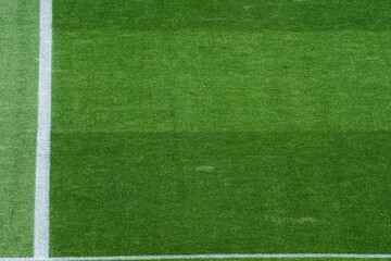 Obraz premium Background Texture of International-Standard Football Pitch with Striped Grass and Field Lines Under Clear Conditions