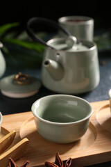 Fototapeta premium Set for tea ceremony with tray and cup on blue grunge background, closeup
