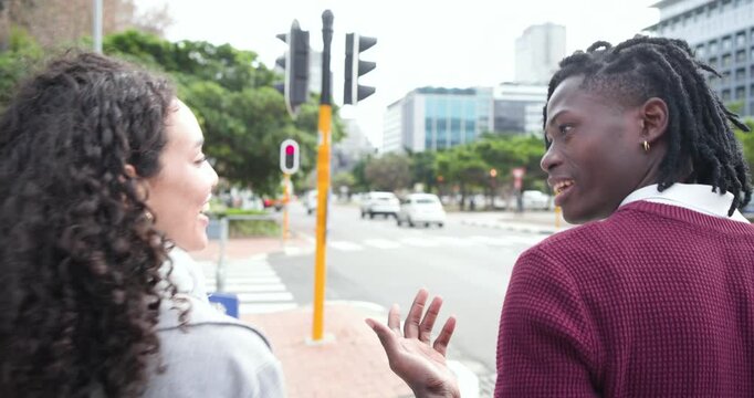 Diverse friends stepping onto crosswalk as traffic light turning green and chatting on city street