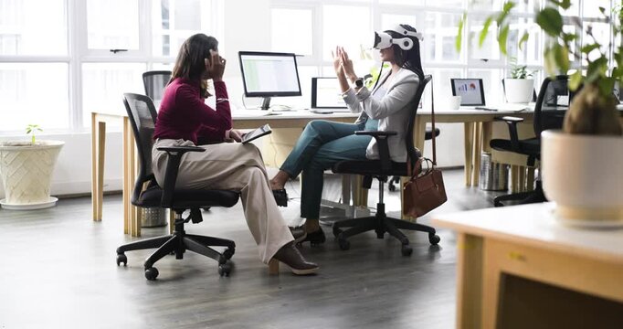 African American woman at office reacting to VR cue adjusting headset and demonstrating interface