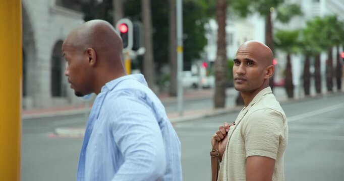 Diverse male friends glancing at walk light changing, stepping from curb and crossing with bag