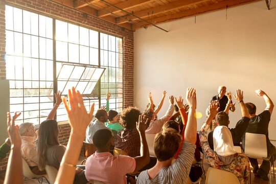 Engaged audience raising hands.