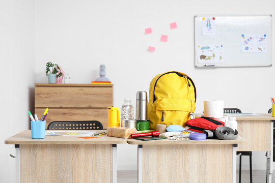 School desk with emergency backpack and necessities in classroom