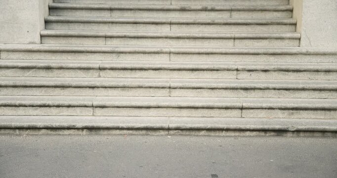 Runner is sprinting into frame across path by stone staircase, and people are walking toward steps