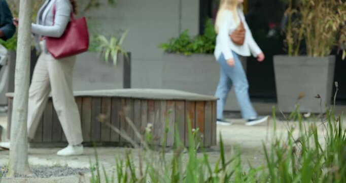 Woman angling smartphone is causing man to lean in while grabbing red tote, heading toward entrance