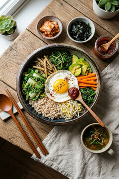 도자기 그릇에 정갈하게 담긴 한국 전통 봄동 보리 비빔밥과 된장국 한상차림