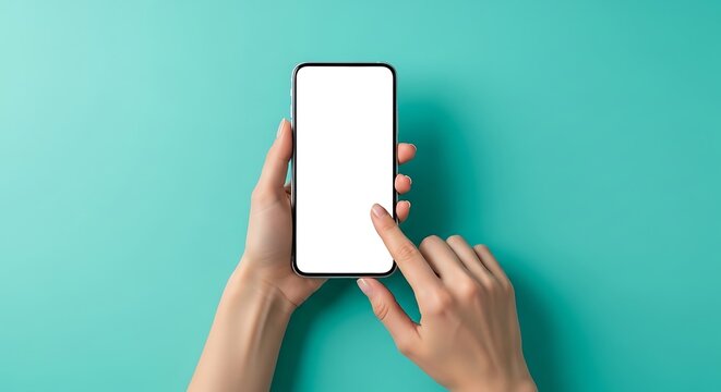 Top-down perspective of a person's hands holding and interacting with a modern smartphone with a blank white screen against a vibrant teal backdrop, emphasizing digital engagement.