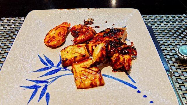Grilled shrimp and squid in spicy glaze served on a ceramic plate design