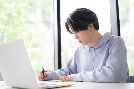 大学のキャンパスや予備校などの授業をうける大学生のような若い男性の教室や講義室で真面目に勉強する春や緑の爽やかなイメージの横顔
