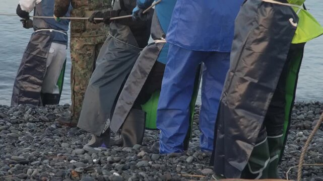 海岸から網を引く漁師