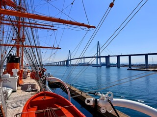 Majestic view of the tall ship Kaiwo Maru and Shinminato Bridge against the snowy Tateyama Mountains in Toyama, Japan.