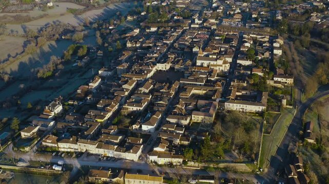 Aerial view of the geometric grid pattern and red tiled roofs in the historic village of Monpazier. Overhead drone perspective.