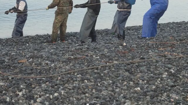 海岸から網を引く漁師