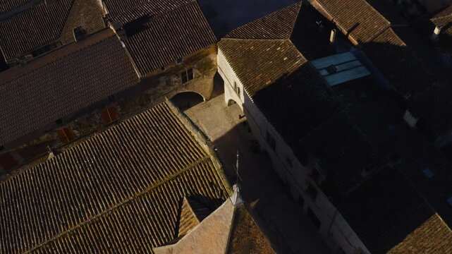 Medieval architecture and the covered arcades of the main square in Monpazier Dordogne shown from a downward drone view.