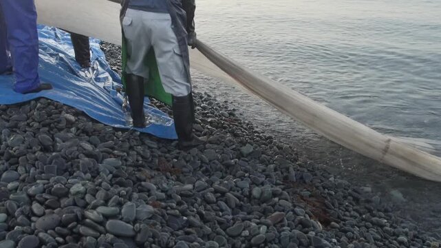 海岸から網を引く漁師