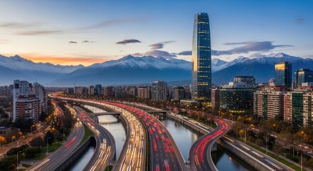 Fototapeta premium Modern Cityscape At Dusk With Mountain Backdrop And Traffic Trails
