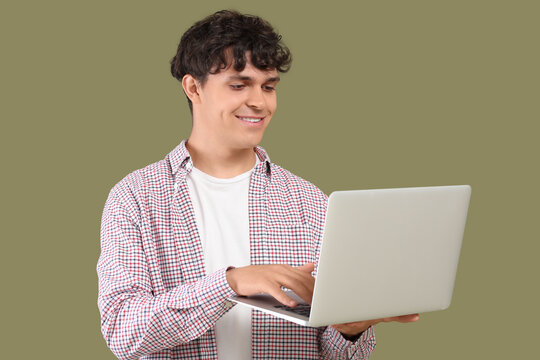 Male programmer working with laptop on green background