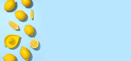 Fototapeta premium Fresh ripe lemons and juicer on blue background with space for text, top view